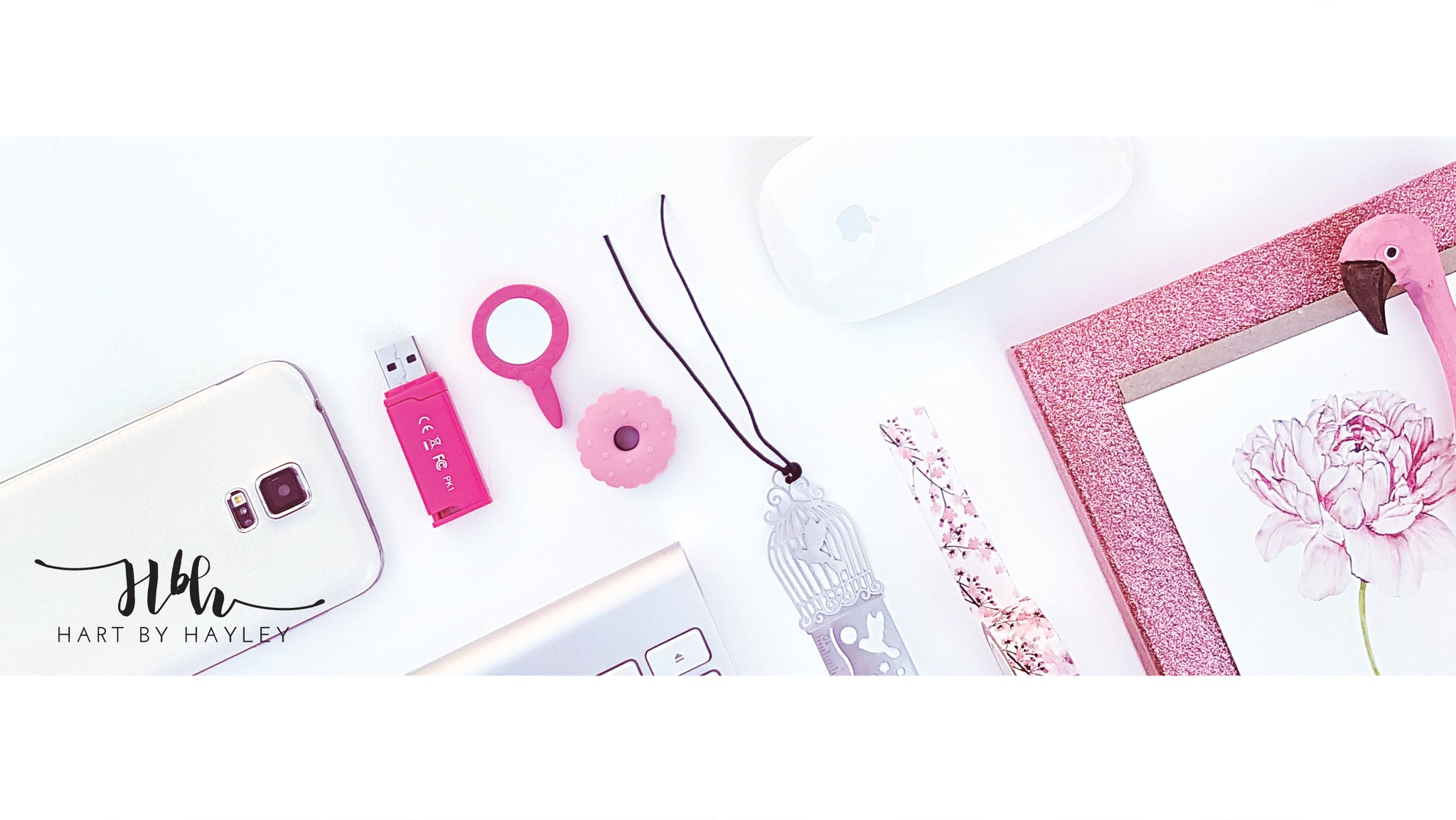White desk Banner with pink accessories.